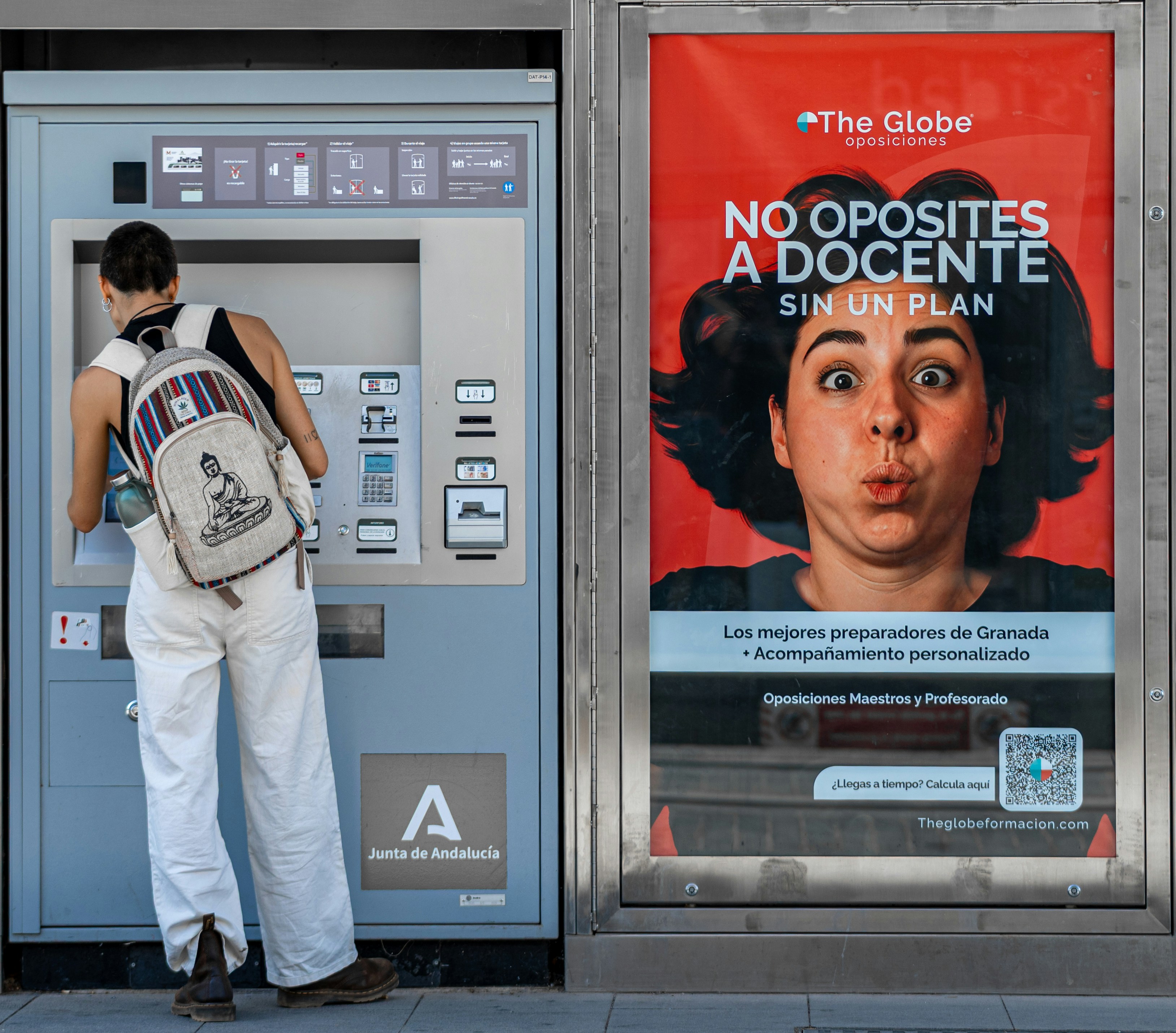Woman using ticket machine next to advertisement